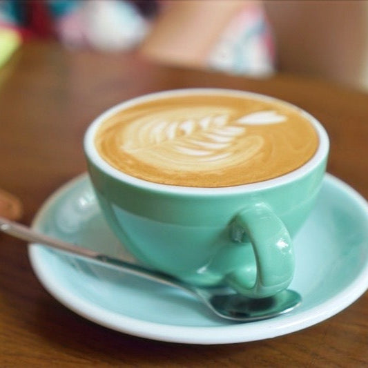 Flat white in a coffee cup in cafe